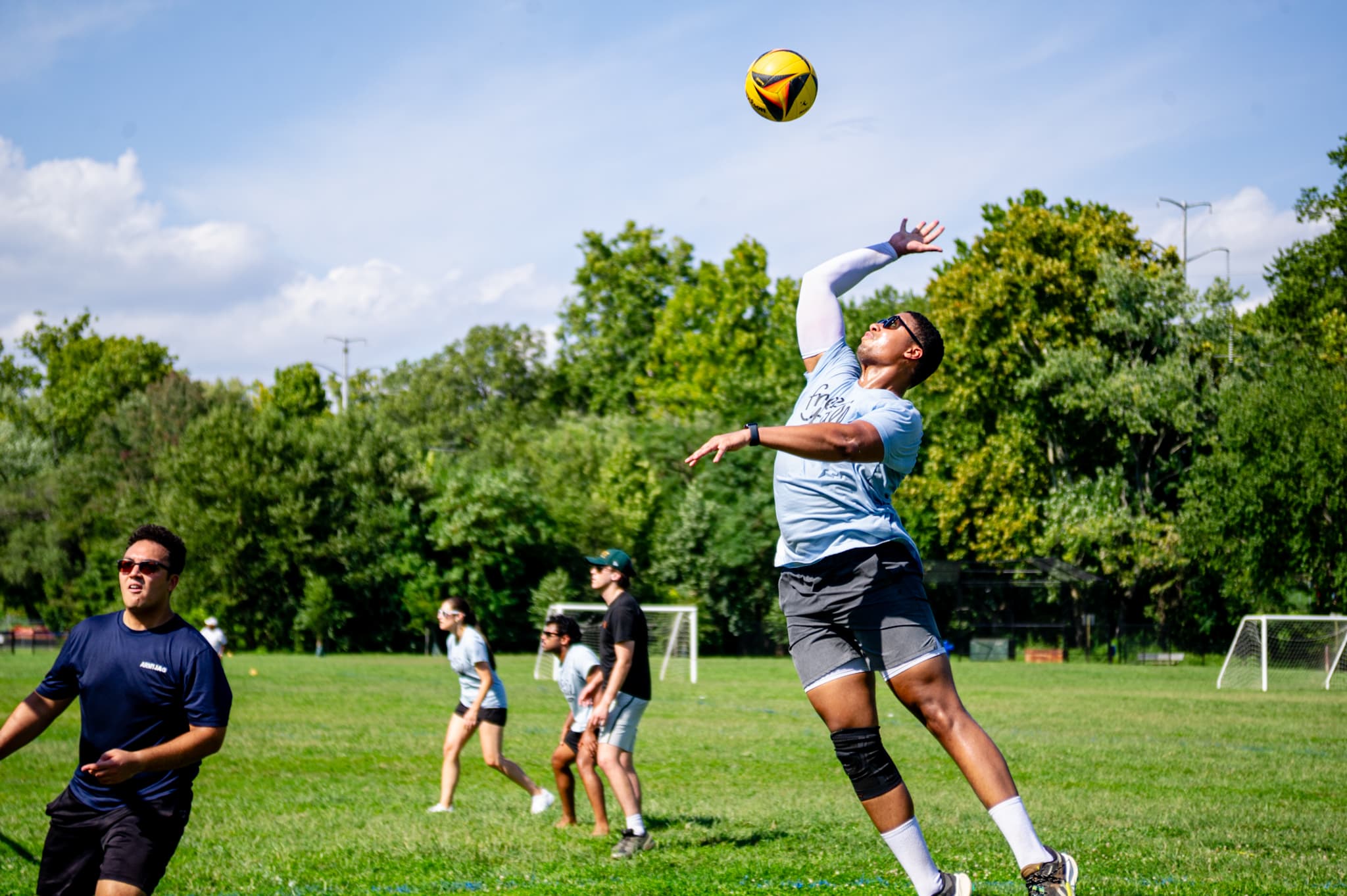 Players competing at a FREEBALL grass volleyball match